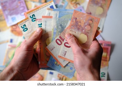 closeup male hands count paper euro banknotes of european union, paper bills on table, concept of cash, payments, savings, banking, save up for vacation, got low salary, social security, pay taxes - Shutterstock ID 2158347021