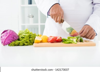 Close-up of male hands cutting vegetables on the board - Powered by Shutterstock