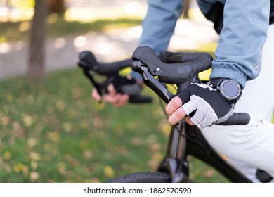 close-up of male hands hold the handlebars of a bicycle while riding.
