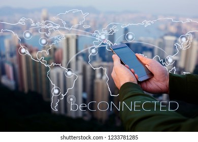 Closeup of male hands holding modern smartphone against cityscape skyscrapers  view. Infographics world map with connection network. Communication with internet everywhere.  Mobile phone for chatting
