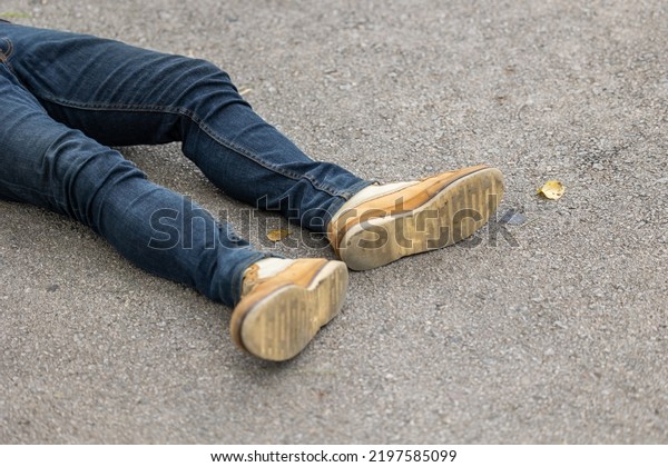 closeup male leg lay down on asphalt road.\
pedestrian hit accident by car\
concept.