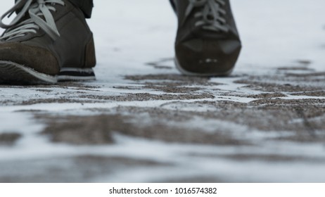 Close-up of male legs in winter shoes walking on snow. Footage, View of walking on snow with Snow shoes and Shoe spikes in winter. Men's legs in boots close up the snow-covered path