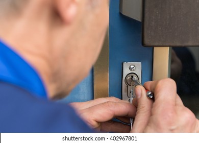 Close-up Of Male Lockpicker Hand Fixing Door Handle At Home