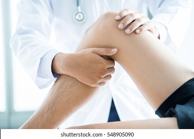 Close-up of male physiotherapist massaging the leg of patient in a physio room. - Powered by Shutterstock