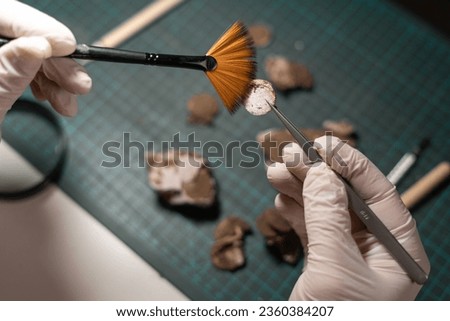 Close-up of male restoring ancient coins, top view. Archaeological concept.