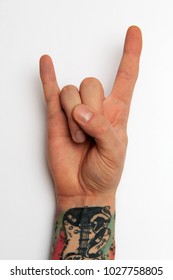 Closeup Male Rocker Metal Concert Sign Hand Isolated On White Background. Closeup Expression Fan Gesture. Teen Modern Rock Music Symbol, Hand With Tattoo.