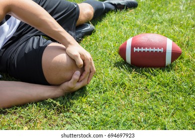 Close-up Of Male Rugby Player Suffering From Knee Injury Lying On Field - Powered by Shutterstock