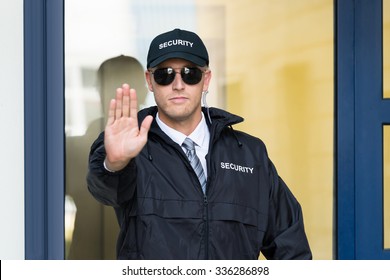 Close-up Of A Male Security Guard Making Stop Sign With Hand Wearing Sunglasses - Powered by Shutterstock