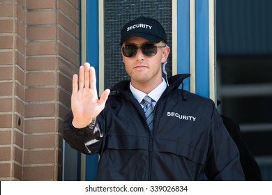 Close-up Of A Male Security Guard Making Stop Sign With Hand Wearing Sunglasses - Powered by Shutterstock