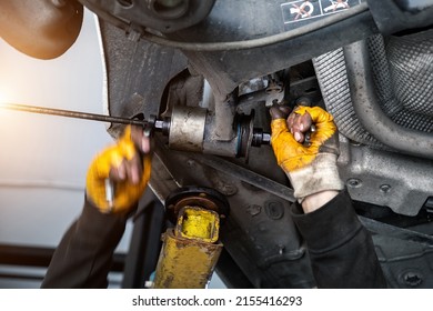 Closeup Male Tehnician Mechanic Greasy Hands In Gloves Install New Car Oem Suspensiom Arm Bushing During Service At Automotive Workshop Auto Center. Vehicle Safety Checkup And Maintenance Concept