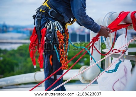 Closeup male worker standing on tank male worker height roof tank knot carabiner rope access safety inspection.