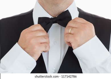 close-up of a man adjusting his bow tie
