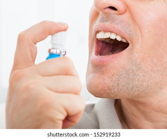 Close-up Of A Man Applying Fresh Breath Spray