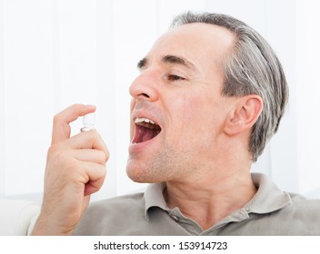 Close-up Of A Man Applying Fresh Breath Spray