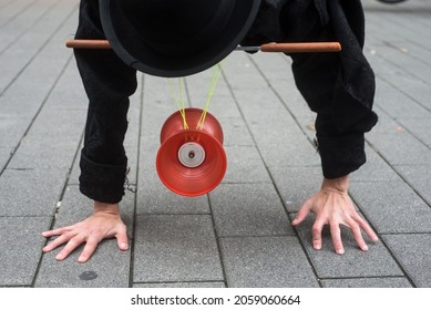 Closeup of man balacing on hands playing with diabolo in the street