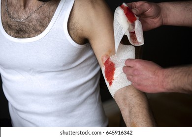 Closeup Of Man With Bloody Wound Getting A Bandage