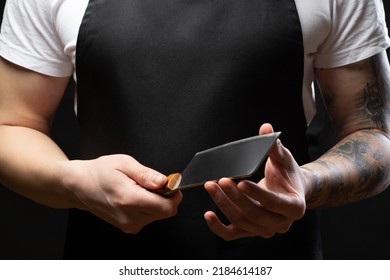 Closeup A Man Butcher Wear Black Apron Holds A Knife Ax For Meat Cutting. Mockup, Place For Text.