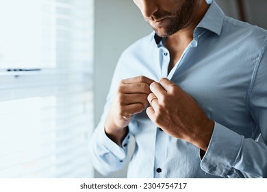 Closeup, man and button shirt of clothes for job interview, work and corporate fashion for business. Hands of male person getting ready in professional outfit from wardrobe in the morning at home - Powered by Shutterstock