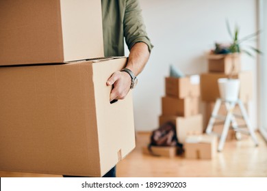Close-up of a man with carton boxes moving into new home.