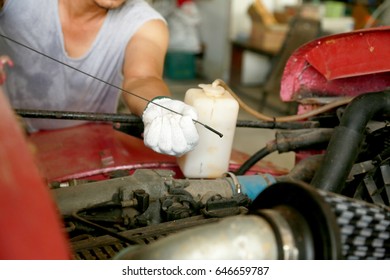 Close-Up Of man Checking Car Engine Oil Level On Dipstick