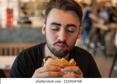 Close-up of a man chewing a burger.