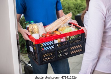 Close-up Of Man Delivers Crate Of Groceries At Home