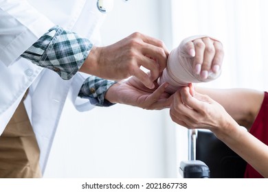 Close-up of man doctor with wrapping nurse bandages splint to the arm of a female patient wear arm splint with analogue pressure gauge for better healing In the room hospital background. - Powered by Shutterstock