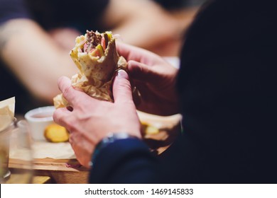 Close-up Of Man Eating Doner Kebab Hand.