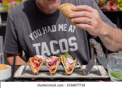 Closeup Of Man Eating Gourmet Shrimp Tacos At Outdoor Restaurant In Summer