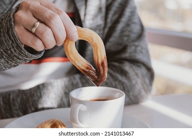 Close-up Of A Man Eating A Typical Sweet Spanish Breakfast And Churros With Chocolate