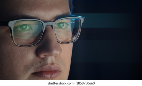 Closeup Of Man Eyes In Eyeglasses In Front Of The Computer, Gimbal Pan Shot Right To Left, Concentrated Look. Young Man Sitting Working Alone At Night