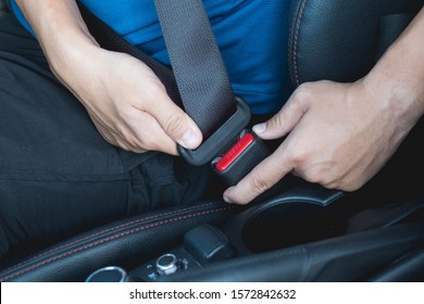 Closeup of man fastening seat belt in car
