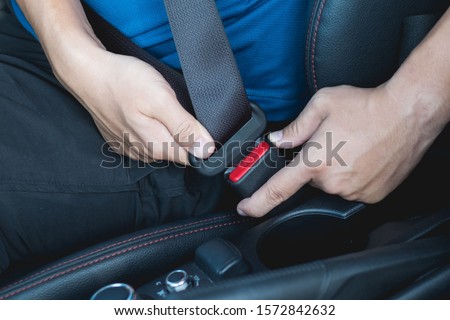 Closeup of man fastening seat belt in car
