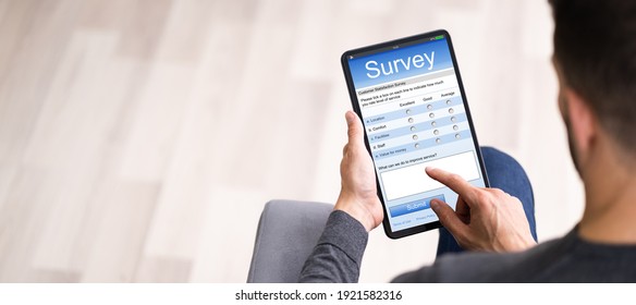 Close-up Of A Man Filling Online Survey Form On Digital Tablet