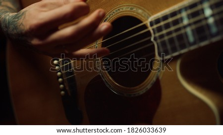 Similar – Image, Stock Photo Hand holding an acoustic guitar with black background with a dramatic and cinematic tone in chiaroscuro