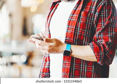 Close-up Of Man With Flannel Shirt. Using Mobile Phone