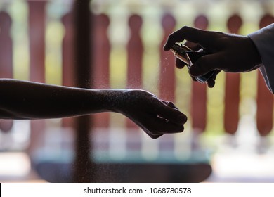 Closeup Of Man Hand Applying Perfume On Beautiful Young Woman Wrist