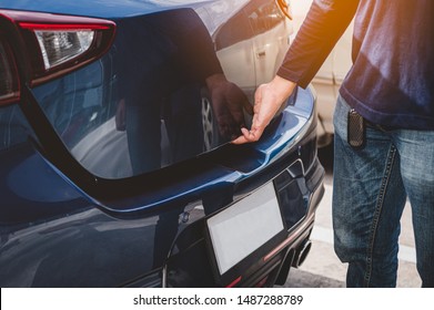 Closeup of man hand opening hatchback trunk by touching sensor door. People lifestyle and transportation technology. Travel and road trip concept. Automotive transportation and outdoors theme