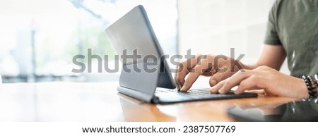 Closeup man hand using digitaltablet, typing on magic keyboard, copy space.