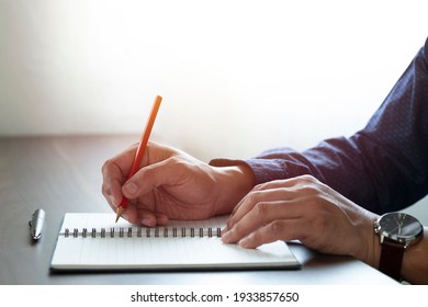 Close-up of man hand using writing pencil memo on notebook paper or letter, diary on table desk office. Workplace for student, writer with copy space. business working and learning education concept. - Powered by Shutterstock