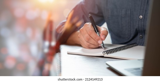 Close-up of man hand using writing pen memo on notebook paper or letter, diary on table desk office. Workplace for student, writer with copy space. business working and learning education concept.