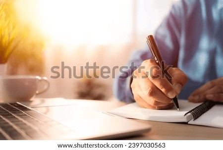 Close-up of man hand using writing pen memo on notebook paper or letter, diary on table desk office. Workplace for student, writer with copy space. business working and learning education concept.