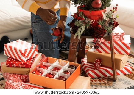 Closeup man hands decorating Christmas tree wit red toys at home