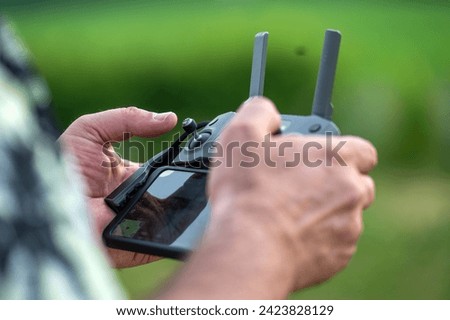 Close-up of a man holding a remote control of a drone, selective focus