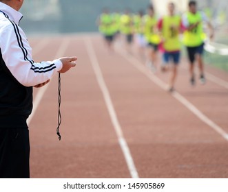 Close-up of a man holding a stopwatch to measure performances of the runners in a stadium 