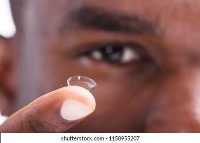 Close-up Of A Man Holding Transparent Contact Lens In His Finger