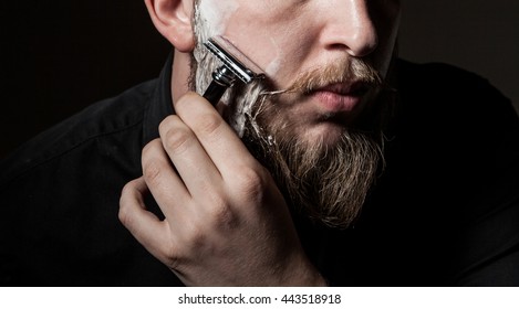 
close-up of a man with a long beard and a mustache , beard shaves with a straight razor - Powered by Shutterstock