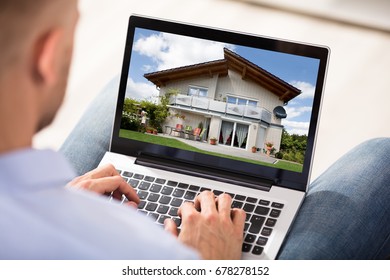 Close-up Of A Man Looking At House Exterior On Laptop Screen