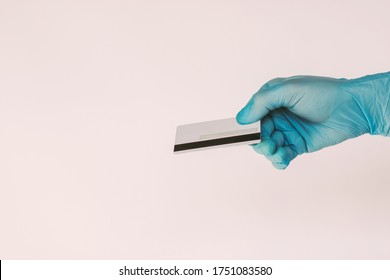 Closeup Man In Medical Latex Glove Hold Blank Credit Card In Hand Isolated On White Background. Male Hand Give Debit Card For Secure Contactless Payment. E-commerce, Cashless Bill, NFC Technology