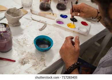 Close-up of man mixing watercolor in palette - Powered by Shutterstock